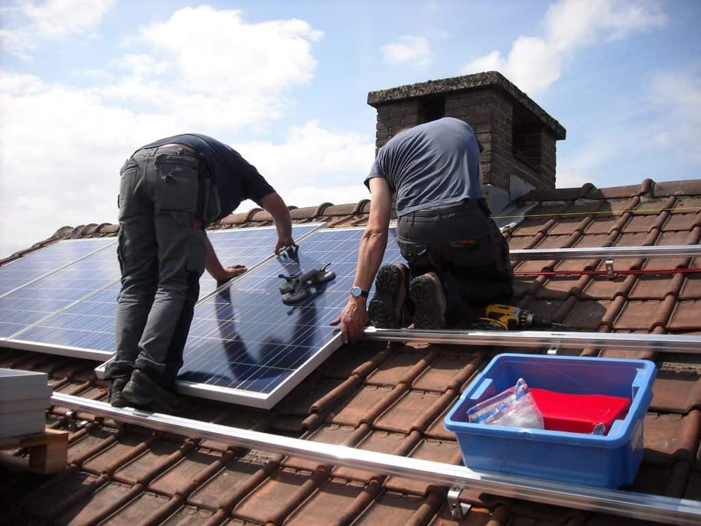 בעלי מקצוע מתקינים פאנלים סולרים על הגג