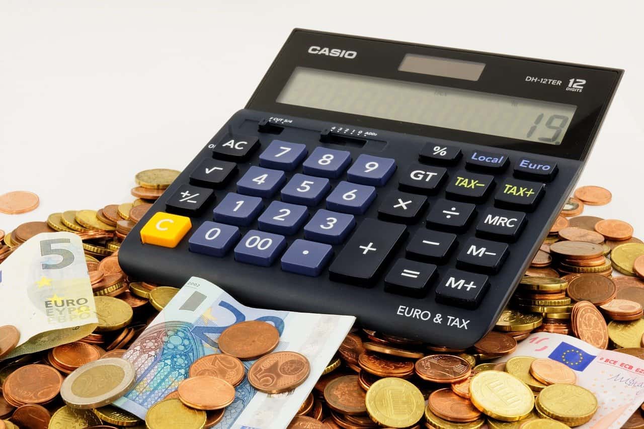 מחשבון ומטבעות כסף על רקע לבן